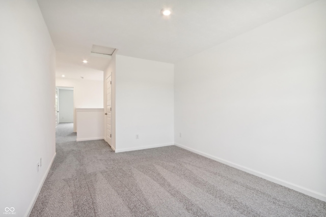 carpeted spare room featuring baseboards, attic access, and recessed lighting