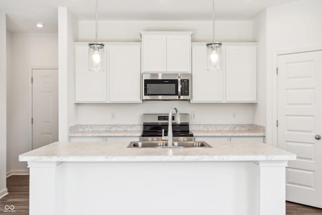 kitchen with a sink, white cabinetry, appliances with stainless steel finishes, a center island with sink, and dark wood finished floors