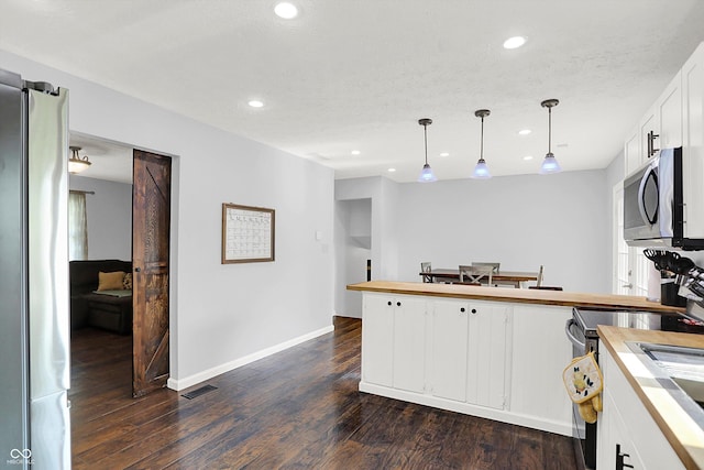 8315 San Marcos Cir, Indianapolis, IN 46256 - kitchen with stainless steel appliances, a peninsula, white cabinets, dark wood-style floors, and recessed lighting