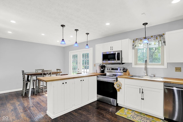 8315 San Marcos Cir, Indianapolis, IN 46256 - kitchen featuring appliances with stainless steel finishes, butcher block countertops, a peninsula, and recessed lighting