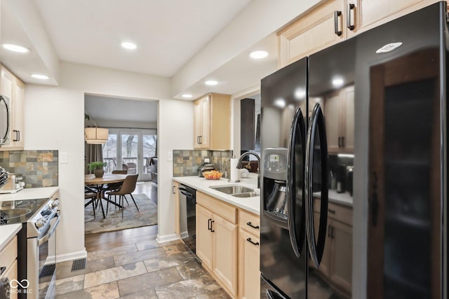kitchen featuring black appliances, recessed lighting, light countertops, a sink, and decorative backsplash