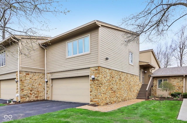 view of side of home featuring a garage, driveway, and stone siding