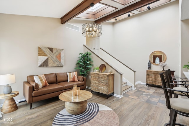 living room with an inviting chandelier, visible vents, wood finished floors, stairs, and beam ceiling