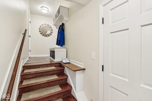 staircase featuring baseboards