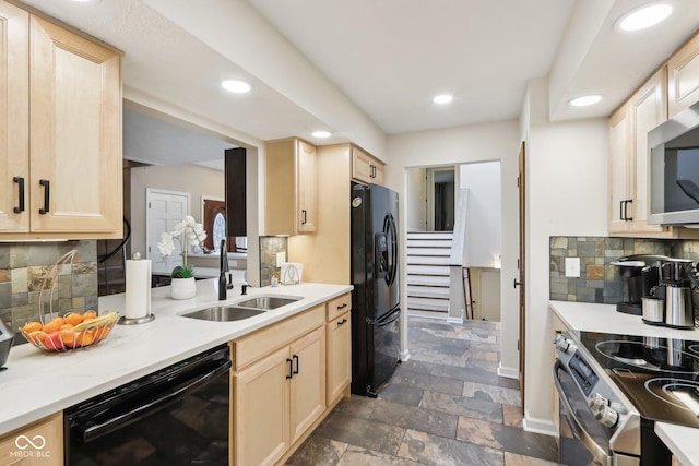 kitchen featuring light brown cabinetry, a sink, and black appliances