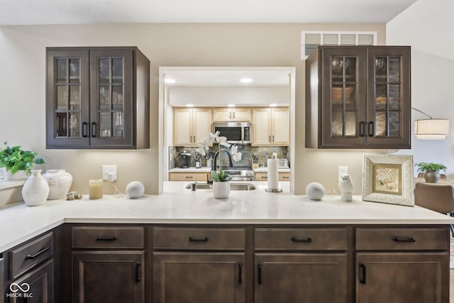 bar with visible vents, recessed lighting, stainless steel microwave, a sink, and decorative backsplash