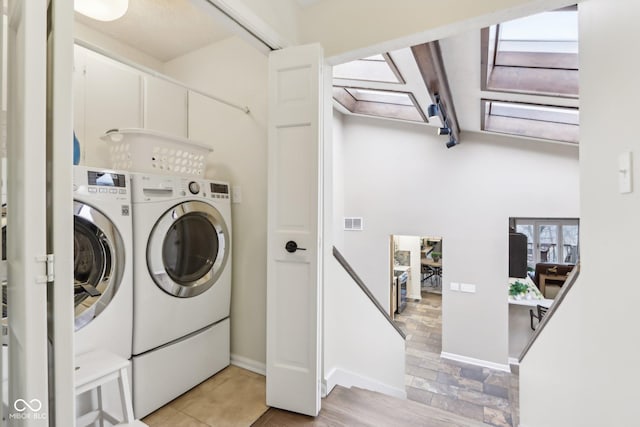 washroom with visible vents, baseboards, washing machine and dryer, and laundry area