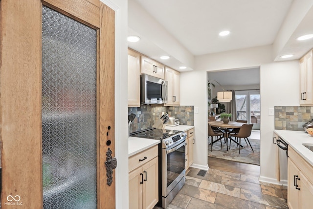 kitchen with recessed lighting, tasteful backsplash, light countertops, and appliances with stainless steel finishes