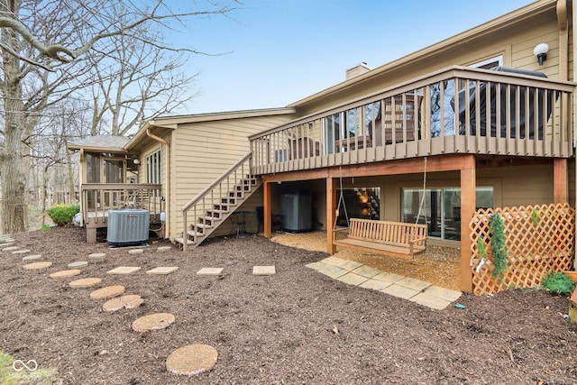 back of house with stairway, a deck, central air condition unit, and a sunroom