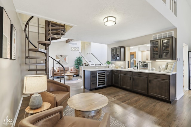 bar featuring dark wood-style flooring, beverage cooler, visible vents, and stairs