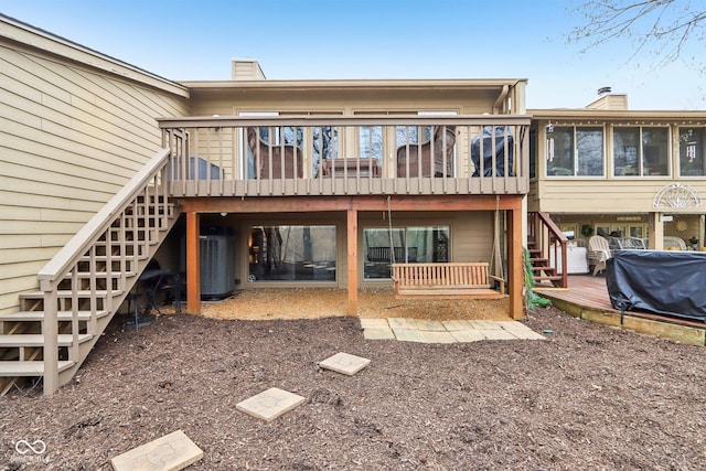 back of property with central AC, a wooden deck, stairs, and a chimney