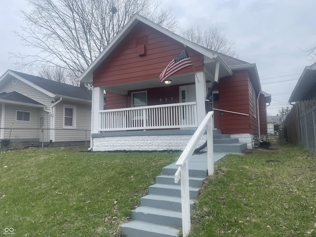 view of front facade featuring a front lawn, fence, and a porch