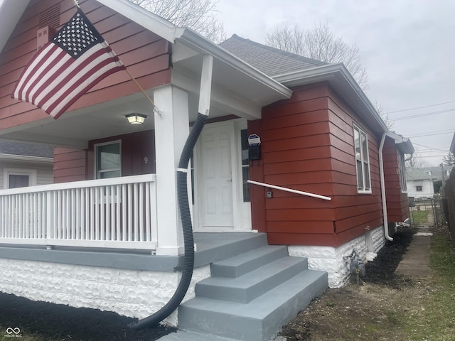 view of side of home featuring covered porch