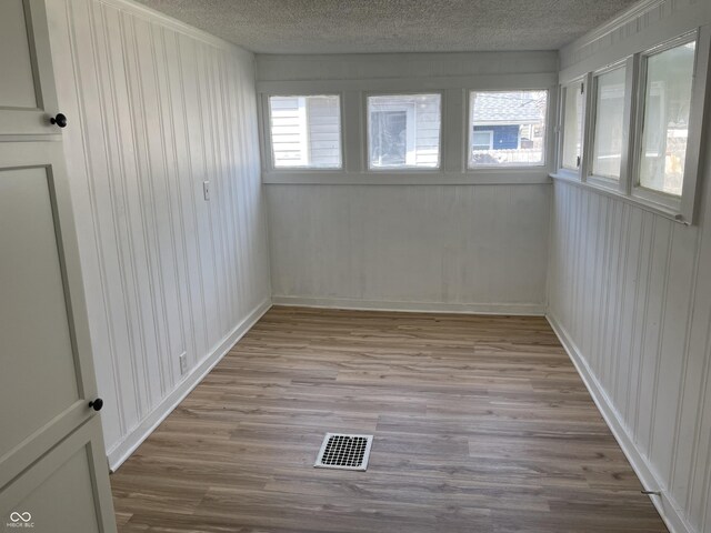unfurnished sunroom featuring visible vents