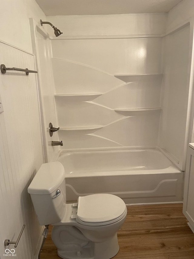 bathroom featuring wood finished floors, toilet, and shower / bath combination