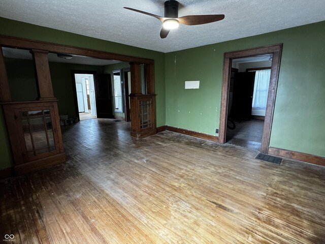 3179 W 400 N, Fairland, IN 46126 - unfurnished living room with wood finished floors, baseboards, a ceiling fan, and a textured ceiling