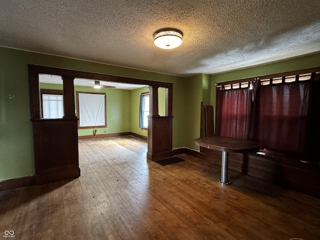 3179 W 400 N, Fairland, IN 46126 - unfurnished dining area with baseboards, hardwood / wood-style floors, a textured ceiling, and ornate columns