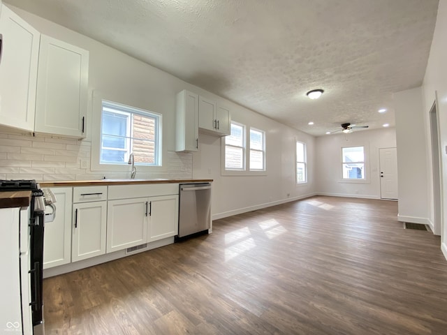1518 Lawton Ave, Indianapolis, IN 46203 - kitchen featuring appliances with stainless steel finishes, wood counters, a textured ceiling, backsplash, and dark wood-style floors