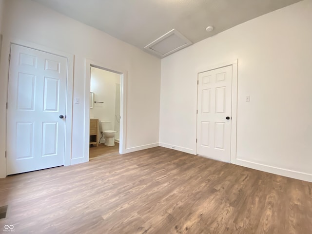 1518 Lawton Ave, Indianapolis, IN 46203 - unfurnished bedroom featuring attic access, wood finished floors, and ensuite bathroom