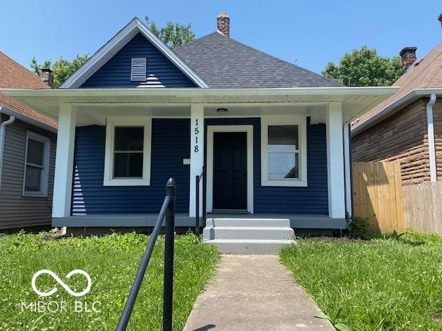 1518 Lawton Ave, Indianapolis, IN 46203 - bungalow-style home featuring a shingled roof, a chimney, and covered porch