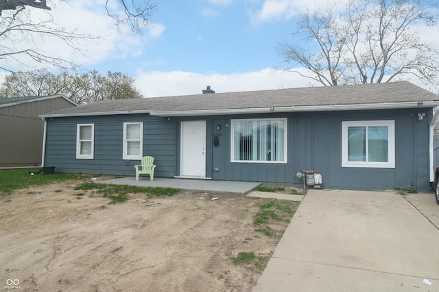 single story home with a patio area, board and batten siding, and a shingled roof