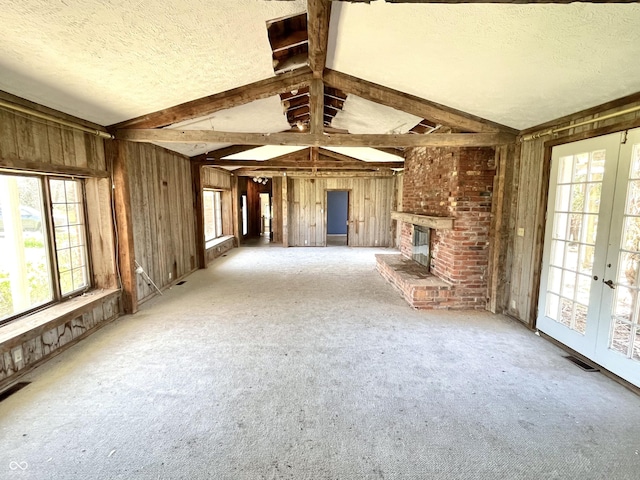 7180 N State Road 42, Eminence, IN 46125 - unfurnished living room with wood walls, a fireplace, visible vents, and a textured ceiling