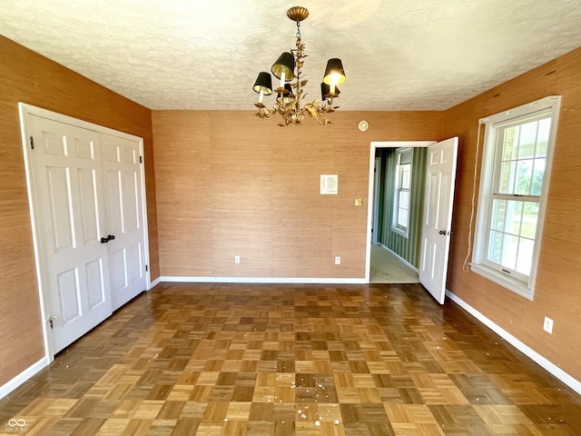 7180 N State Road 42, Eminence, IN 46125 - unfurnished dining area featuring baseboards, a textured ceiling, and an inviting chandelier