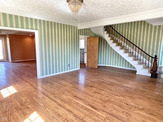 7180 N State Road 42, Eminence, IN 46125 - unfurnished living room featuring ornamental molding, a textured ceiling, stairway, wood finished floors, and wallpapered walls