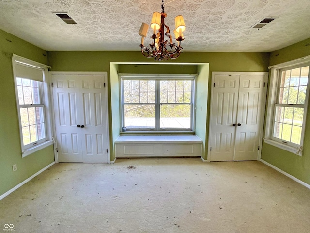 7180 N State Road 42, Eminence, IN 46125 - unfurnished bedroom featuring an inviting chandelier, carpet flooring, visible vents, and two closets