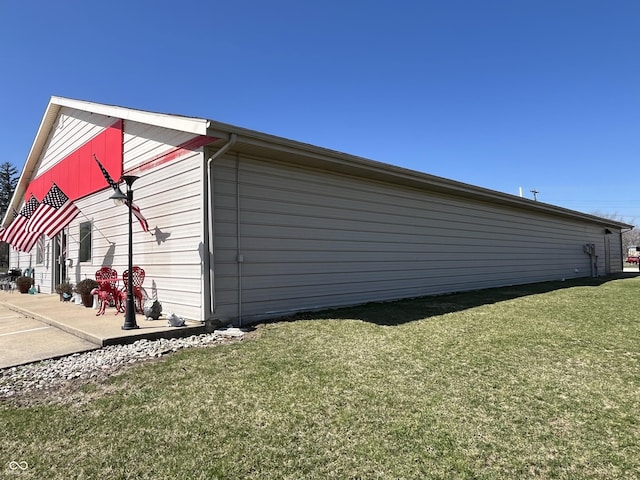 view of side of property with a lawn and a patio area