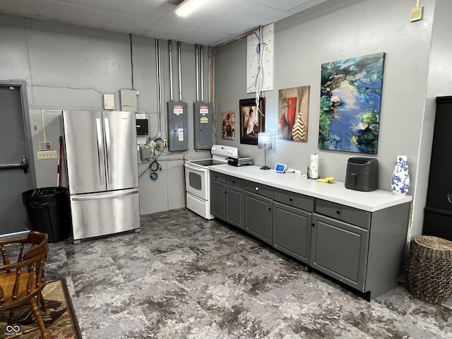 kitchen featuring freestanding refrigerator, gray cabinets, light countertops, and electric range
