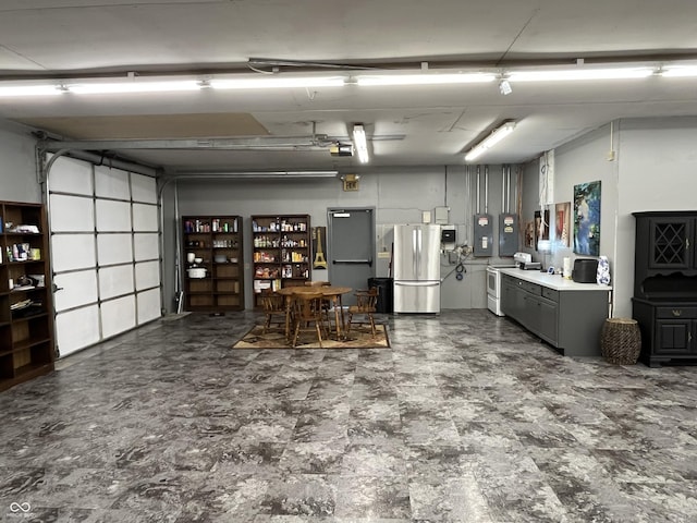 garage with electric panel, a garage door opener, fridge, and freestanding refrigerator