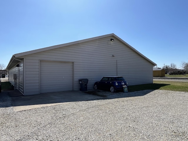 view of home's exterior with driveway and an outbuilding