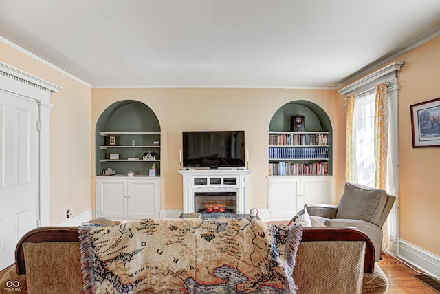 110 E Hendricks St, Shelbyville, IN 46176 - living room with crown molding, built in shelves, a glass covered fireplace, baseboards, and visible vents