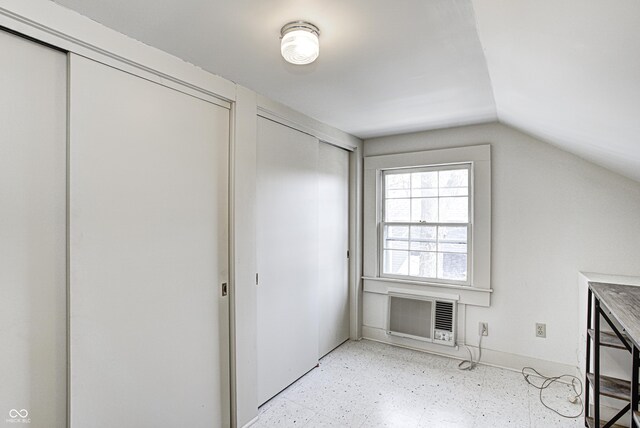 110 E Hendricks St, Shelbyville, IN 46176 - interior space with an AC wall unit, baseboards, vaulted ceiling, and light floors