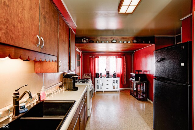 110 E Hendricks St, Shelbyville, IN 46176 - kitchen with light countertops, gas range gas stove, baseboards, a sink, and freestanding refrigerator