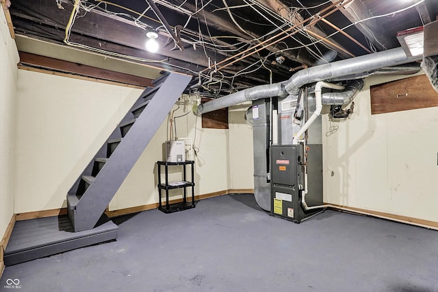 unfinished basement with heating unit, baseboards, and stairway