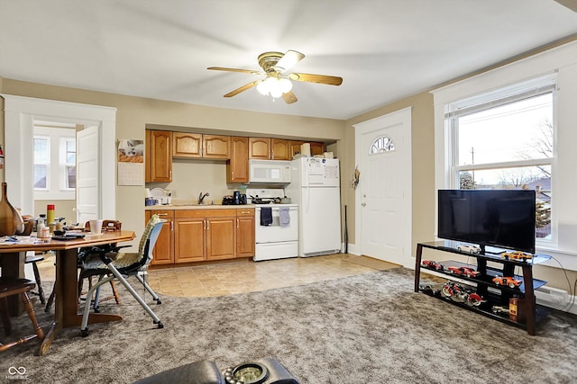 kitchen with light countertops, white appliances, ceiling fan, a sink, and light colored carpet