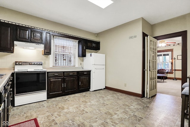 kitchen featuring light countertops, freestanding refrigerator, under cabinet range hood, range with electric cooktop, and baseboards