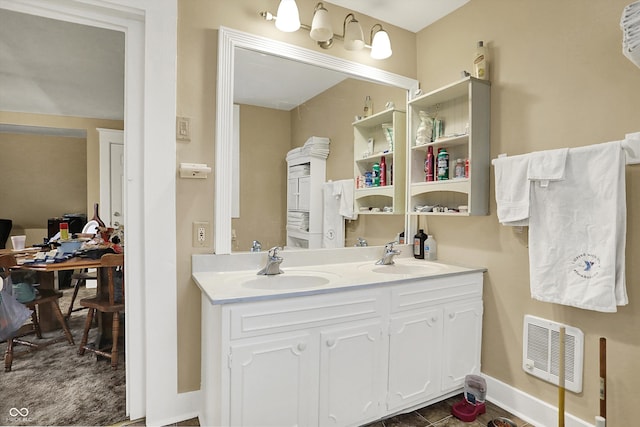 full bathroom featuring a sink, double vanity, visible vents, and baseboards