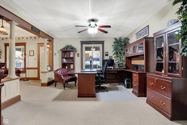 carpeted home office featuring a wealth of natural light, ceiling fan, and ornate columns