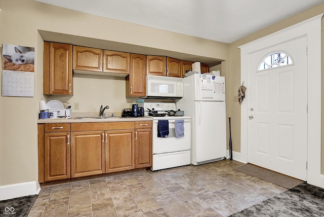kitchen with a sink, brown cabinets, and white appliances