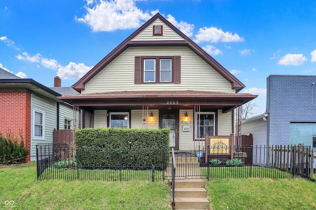 bungalow-style home featuring covered porch, a front yard, and a fenced front yard