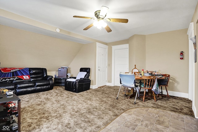 carpeted living room featuring baseboards, vaulted ceiling, and a ceiling fan