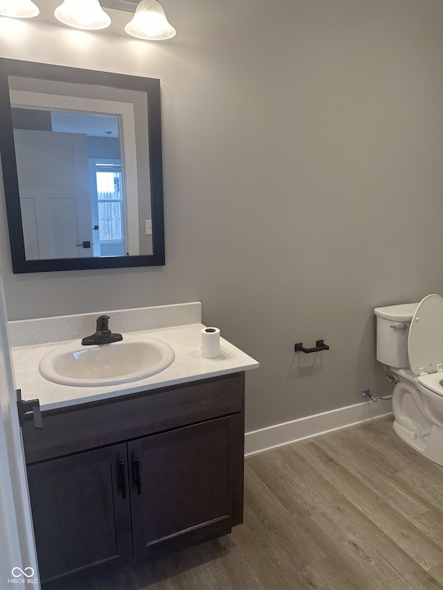 1746 Lambert St, Indianapolis, IN 46221 - half bathroom with baseboards, toilet, wood finished floors, and vanity