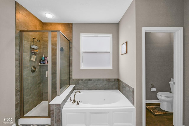 bathroom with a shower stall, a garden tub, and toilet