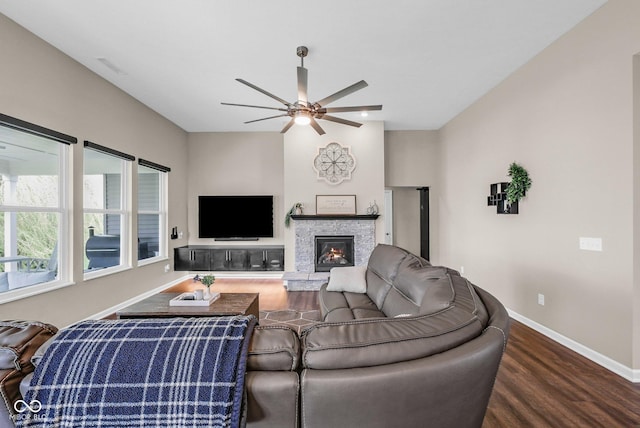 living room with visible vents, baseboards, ceiling fan, a fireplace, and wood finished floors
