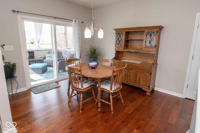 dining area featuring baseboards, a chandelier, and dark wood finished floors