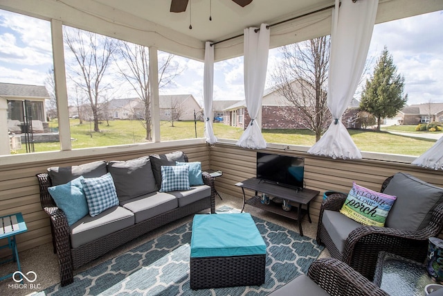 sunroom / solarium with a residential view, a wealth of natural light, and ceiling fan