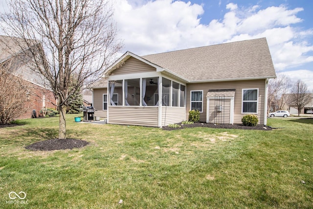 rear view of house featuring roof with shingles, a sunroom, a yard, and ceiling fan